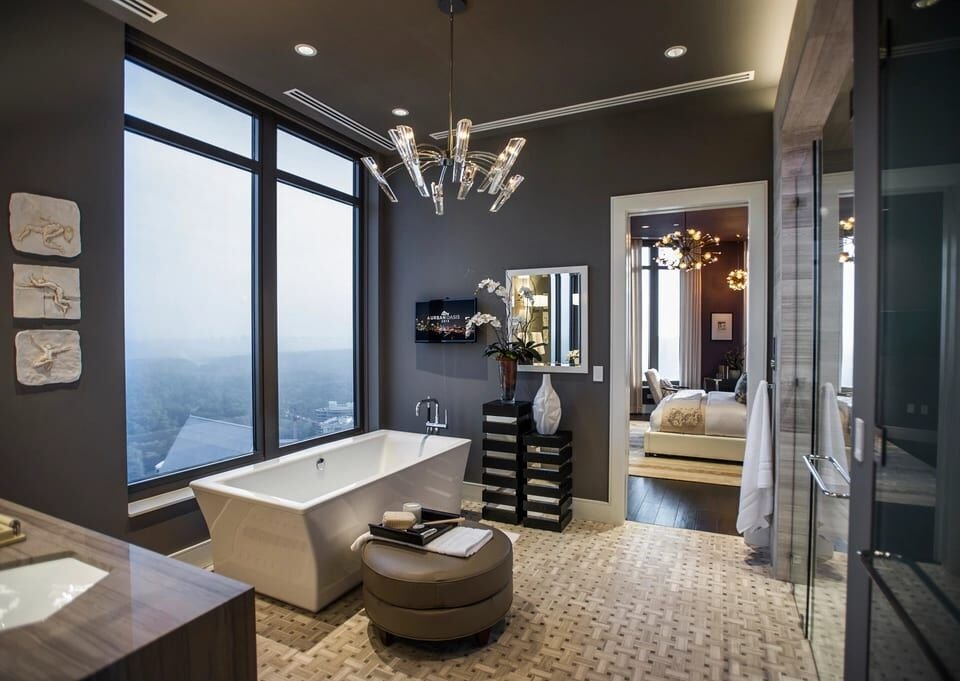 Primary bath with a freestanding tub, chandelier and city view