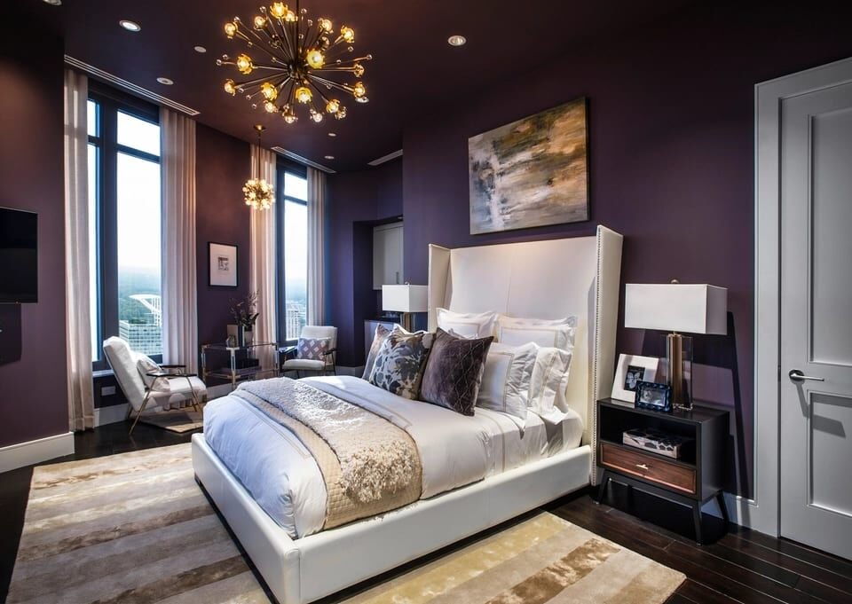 Primary bedroom with a tufted headboard and a sputnik chandelier