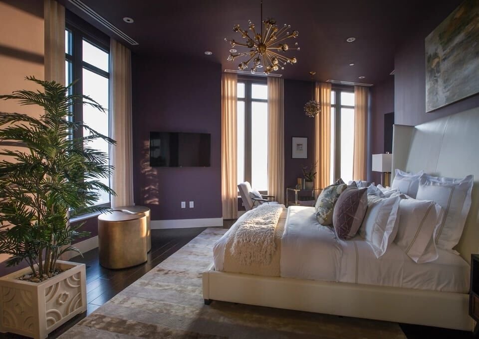 Calm primary suite with tall windows and soft bedding