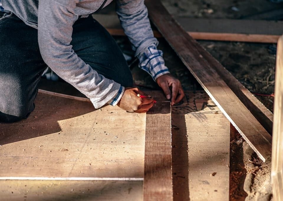 Craftsman fitting wood flooring by hand