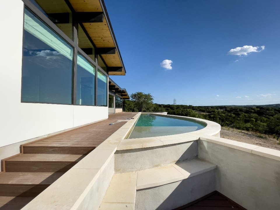 Modern home terrace with a curved infinity-edge pool