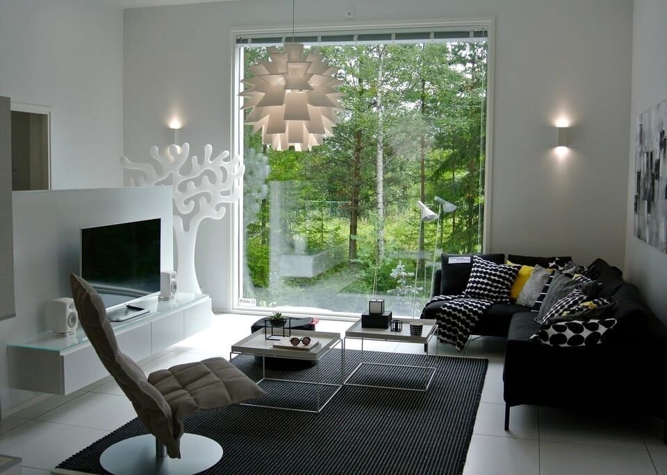 Modern living room with a sculptural pendant and garden views